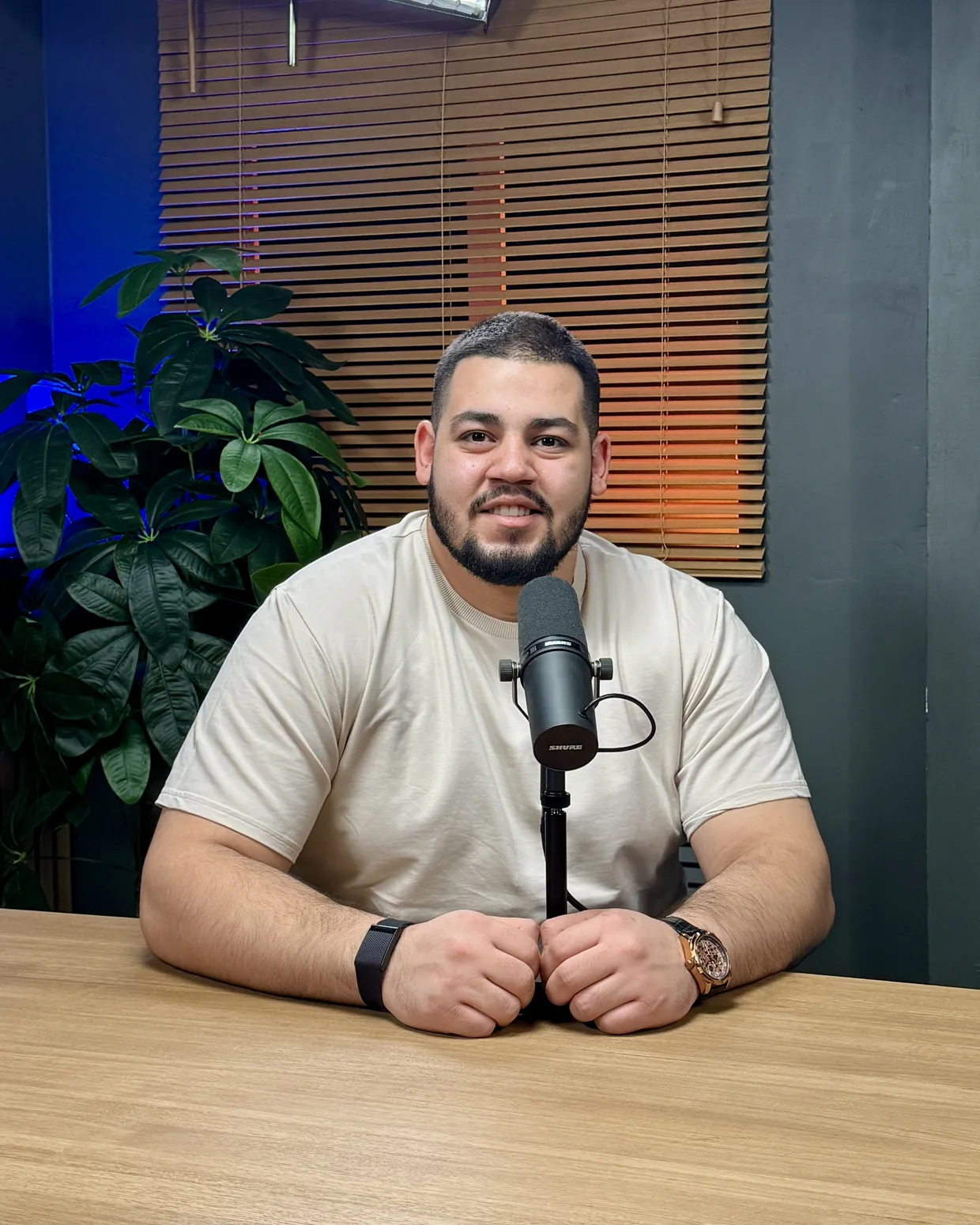 Nabil Kamel at a microphone in a podcast studio